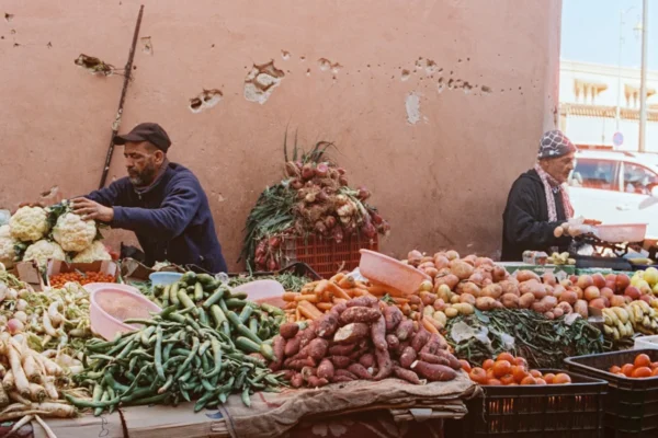 A man standing in front of a table filled with fruits and vegetables