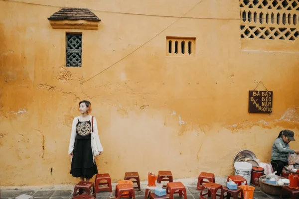 a woman standing in front of a yellow wall