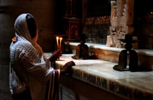 a woman holding a lit candle in a church